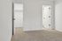 Inviting bedroom with plush carpet, connected to a walk-in closet and modern bathroom.