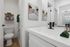 Elegant and modern bathroom with sleek fixtures, wall art, and neatly arranged towels, creating a fresh and inviting atmosphere.