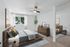 Elegant bedroom with modern decor, featuring a cozy bed, stylish wooden furniture, and a large window with natural light.
