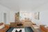 Chic modern living area with hardwood flooring, cozy dining nook, stylish bookcase, and contemporary art on the walls.
