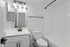 Modern bathroom with sleek fixtures, bright lighting, and a stylish white vanity.