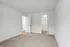 Bright and spacious bedroom with plush carpet, featuring a modern walk-in closet and crisp white walls.