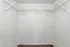 Spacious walk-in closet with pristine white walls and durable wire shelving.