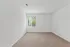 Bright and airy room with plush carpeting, featuring a large window framing lush green views.