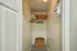 Charming walk-in closet featuring elegant wicker baskets, a sleek white shelf, and polished wooden hangers in a modern setting.