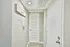 Inviting hallway entrance with sleek white door, modern thermostat, and elegant 'Home Sweet Home' sign, creating a warm welcome.