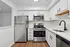 Elegant modern kitchen with sleek stainless steel appliances, pristine white cabinetry, and luxurious wood flooring.