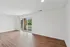 Bright and airy living space with sleek wooden flooring and large sliding glass doors opening to a charming balcony, perfect for relaxing.