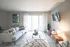 Bright and inviting living room with modern decor, featuring a chic gray sofa, stylish coffee table, and a large sliding glass door letting in natural light.