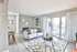 Bright and inviting living room with modern decor, large sliding glass doors, and a cozy sofa set, opening to a charming balcony with serene views.