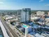 Modern high-rise apartment building with glass facade and rooftop pool offering stunning cityscape views.