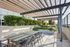 Elegant outdoor patio with modern pergola, stylish seating area, and lush greenery for a serene ambiance.