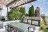 Luxurious outdoor rooftop patio featuring a modern pergola, sleek grill station, and lush greenery, perfect for entertaining and relaxation.