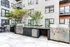 Sleek modern outdoor barbecue area with stainless steel grills, perfect for entertaining in a stylish apartment courtyard.