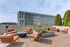 Chic rooftop terrace with vibrant orange seating, modern planters, and stunning city views for relaxing and entertaining.