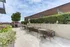 Charming outdoor terrace with modern seating, lush greenery, and a sleek pergola, perfect for city skyline views.