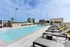 Luxurious rooftop pool area with chic lounge chairs and modern cityscape views.