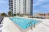 Luxurious apartment complex with a sparkling outdoor pool and sun loungers, offering perfect urban living and relaxation.