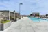 Luxurious rooftop pool area with modern cabanas and elegant lounge chairs, offering stunning city views.