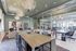 Elegant and spacious room featuring modern industrial design with large windows, stylish lighting, and upscale décor, perfect for meetings or lounging.
