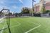 Inviting outdoor soccer field with vibrant green turf, perfect for recreation and exercise, surrounded by modern apartment buildings.
