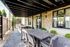 Chic outdoor terrace with sleek dining table, modern seating, and a built-in grill, perfect for stylish entertaining.