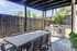 Chic outdoor patio with a modern grill and stylish dining set perfect for entertaining under a sleek pergola.