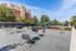 Charming outdoor area featuring modern seating and a vibrant playground, set against a backdrop of lush trees and a brick apartment building.