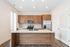 Modern kitchen featuring sleek wood cabinetry, stainless steel appliances, and a spacious island with a polished countertop.