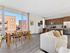 Bright and modern open-concept living space with large windows, cozy seating area, stylish dining setup, and sleek kitchen design.