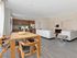 Elegant open-concept living space with modern kitchen, cozy fireplace, and stylish dining area, perfect for entertaining.