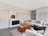 Modern living room featuring elegant white sofas, a unique wooden coffee table, and a sleek built-in fireplace.