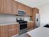 Modern kitchen with sleek wooden cabinets, stainless steel appliances, and a spacious countertop, perfect for culinary creativity.
