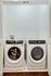 Modern laundry area featuring a sleek washer and dryer set within elegant white cabinetry, promising convenience and style.