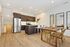 Modern open-concept kitchen and dining area with sleek stainless steel appliances and elegant wooden flooring.