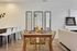 Chic contemporary dining area with elegant table setting and golden accents, complemented by stylish mirrors and modern decor.