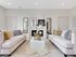 Elegant living room featuring soft beige sofas with decorative cushions, a chic fireplace, and a stylish coffee table centerpiece, creating a cozy and inviting atmosphere.