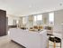 Bright and modern open-concept living and dining area with elegant decor and large windows in a contemporary apartment.