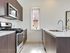 Modern kitchen with sleek dark wood cabinetry, stainless steel appliances, and a bright window creating an inviting cooking space.