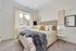 Bright and cozy bedroom featuring a plush bed with stylish decor, modern wall art, and a large window inviting natural light.
