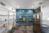 Modern package storage room with organized shelving, bright lighting, and a sleek stainless steel refrigerator, ensuring convenience for residents.