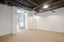 Bright and airy space with modern industrial ceiling and elegant lighting, featuring a cozy neutral carpet and natural light through sleek glass door.