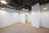 Modern apartment space featuring exposed ceilings and soft lighting, with a cozy carpeted floor and a spacious walk-in closet.