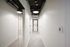 Modern apartment hallway featuring sleek recessed lighting, stylish tile flooring, and a convenient in-unit laundry area.