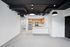 Modern open-concept apartment with sleek industrial design, featuring a spacious kitchen with stainless steel appliances, elegant cabinetry, and a stylish black ceiling with exposed ducts.