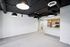 Modern open-concept apartment with sleek industrial ceiling, spacious living area, and contemporary kitchen featuring stainless steel appliances.