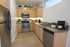 Modern kitchen with stainless steel appliances, sleek wooden cabinets, and elegant countertops, ideal for culinary enthusiasts.
