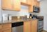 Modern kitchen with stainless steel appliances, granite countertops, and sleek wooden cabinets, ideal for a stylish home.