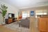 Bright and modern living room with chic furniture, hardwood flooring, and large windows, ideal for cozy living and entertaining.