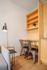 Cozy apartment nook with modern metal chairs, sleek desk, elegant shelving, and warm lighting for a productive environment.